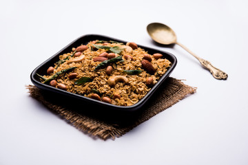 Oats Chivda / Chiwda is a healthy indian recipe with added chilli, peanuts, cashew, almond and curry leaf for flavour. Selective focus