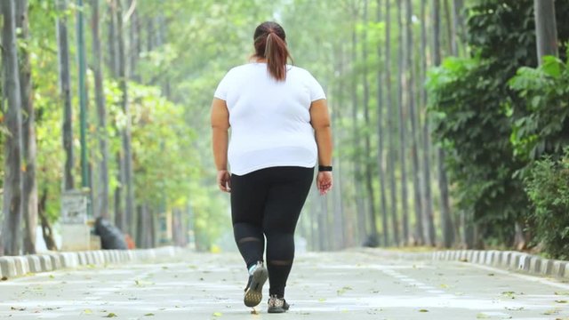 Slow Motion Of Overweight Woman Walking On The Road While Wearing Sportswear