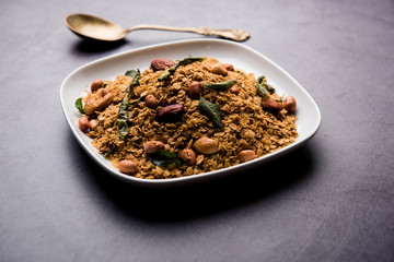 Oats Chivda / Chiwda is a healthy indian recipe with added chilli, peanuts, cashew, almond and curry leaf for flavour. Selective focus