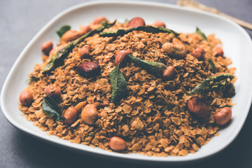 Oats Chivda / Chiwda is a healthy indian recipe with added chilli, peanuts, cashew, almond and curry leaf for flavour. Selective focus