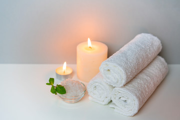 Fototapeta na wymiar SPA and natural health concept photo. White towels, sea salt and candle lights.