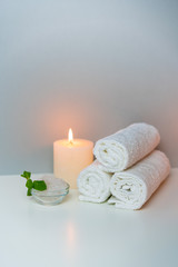 Fototapeta na wymiar SPA procedures concept photo with candle light, sea salt and stack of towels.