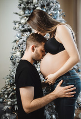 A man kisses a pregnant girl in the tummy