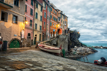 Evening panorama of the town of Riomaggiore in Cinque Terre National Park, multicolored small houses built on rocks turned on evening light of lanterns