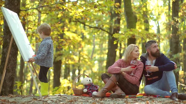 Happy child artist drawing picture on autumn nature. Autumn Family. Happy family. Father mother and children son having fun and playing on autumn nature. Happy Autumn Family. Happy family outdoors.