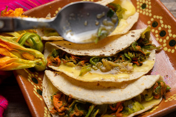 Mexican quesadillas with squash blossom on wooden background