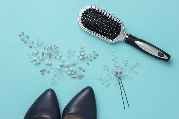 Fees of the bride, wedding day. Decoration in the hair of the bride, comb, high heel shoes on a blue pastel background