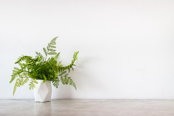 Isolate white jar and tropical green leaves place on grey marble surface table and white and clear Concrete wall. Abstract background  and nobody template with relaxation feeiling clean and clear.
