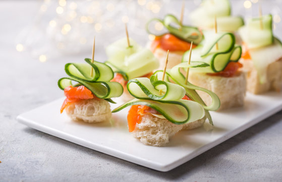 Christmas tree canape or sandwich with cucumber slice, salmon  for festive x-mas snack. New year recipe