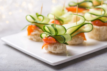 Christmas tree canape or sandwich with cucumber slice, salmon  for festive x-mas snack. New year recipe