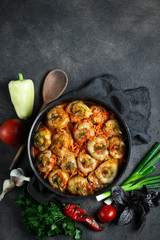 Stuffed peppers with rice, meat and spices in a dark pan on a dark background top view. Copy space.