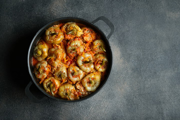 Stuffed peppers with rice, meat and spices in a dark pan on a dark background top view. Copy space.