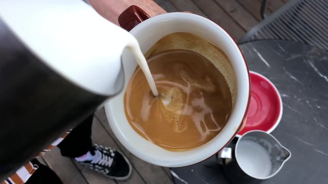 Barista holding coffee cup and make latte art coffee
