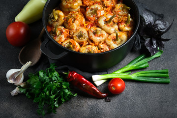 Stuffed peppers with rice, meat and spices in a dark pan on a dark background.