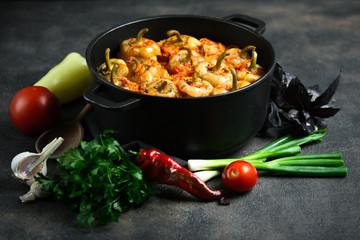 Stuffed peppers with rice, meat and spices in a dark pan on a dark background.