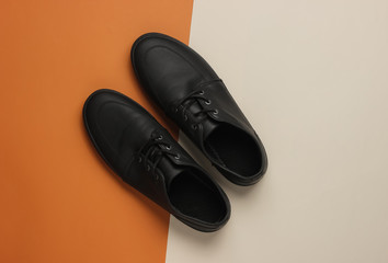 Men's leather black shoes on paper background. Top view