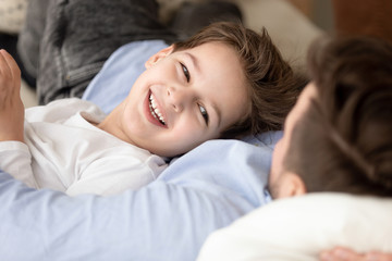 Obraz premium Cute little son lying relaxing with loving father close up