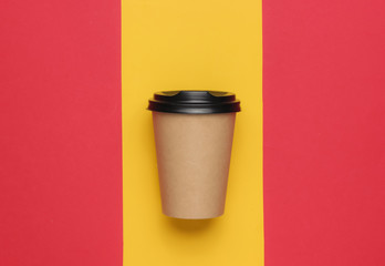 Cardboard coffee cup on a colored paper background. Top view