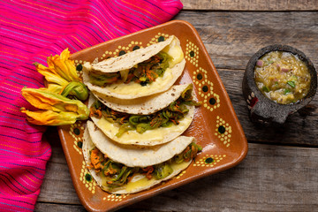 Mexican quesadillas with squash blossom on wooden background