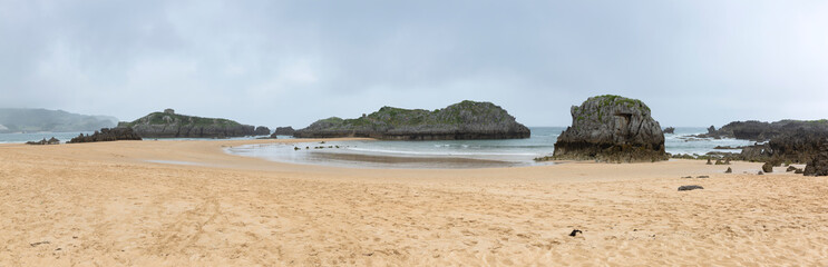 Fototapeta na wymiar Panorámica de la playa de Ris en un día nublado. Noja, Cantabria.