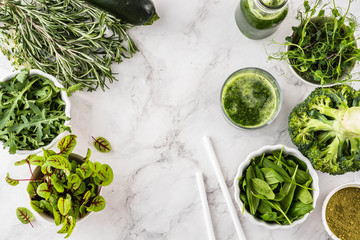 Obraz premium Fresh green vegetables variety on white background from overhead, broccoli, thyme, rosemary, spinach, microgreens.