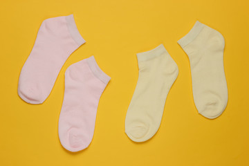 Socks on yellow background. Minimalism fashion concept. Pastel color trend. Top view