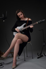 Fototapeta na wymiar Beautiful girl with guitar in recording Studio