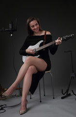 Fototapeta na wymiar Beautiful girl-guitarist in the recording Studio