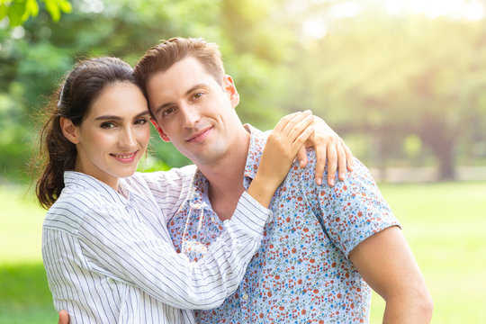 Portrait of Couple lover smiling looking camera outdoor park background with copy space.