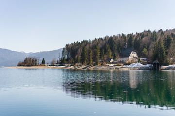 Obraz premium Beautiful landscape with a view of the church located on the shore of a mountain lake in the Alps.