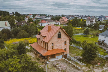 Fototapeta na wymiar Beautiful pink brick brick house and orange roof. Corrugated met