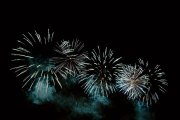 White sparks of a festive fireworks and blue smoke