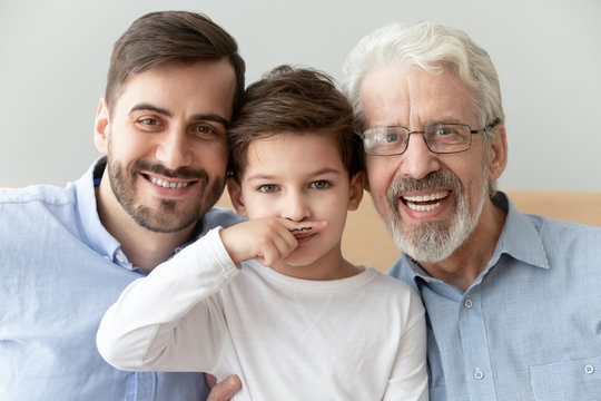 Head shot portrait smiling grandfather, father and preschool son