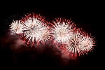 White and red fireworks display on dark sky background