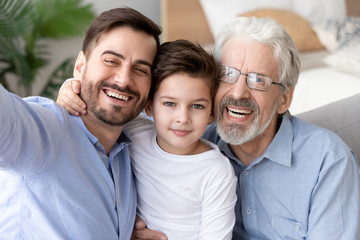 Happy grandfather, father and little son child taking selfie together