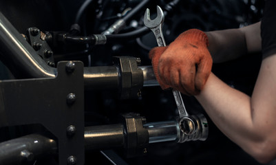 Fototapeta na wymiar Banner with close up view of hand maintenance of oil filters of heavy industry machine. Low key.
