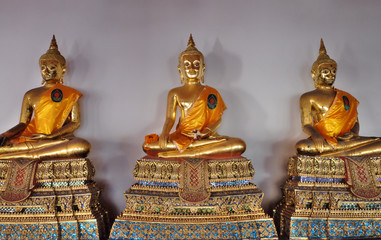 Gilded statues of Buddha sitting in lotus position. Statues from a Buddhist monastery.