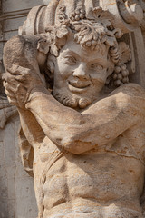 Old sculpture of funny and joyful dickens in downtown of Dresden, Germany, details, closeup