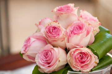 wedding bouquet with roses in pink tone and green leaves
