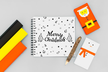 Christmas DIY background concept. Top view of DIY snowman and santa claus gift boxes with Merry Christmas  notebook. Celebration of winter holidays concept