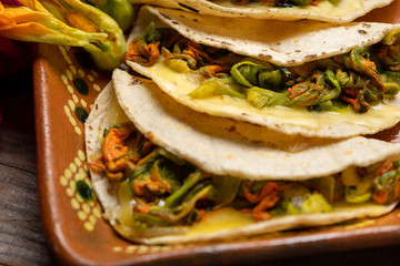 Mexican quesadillas with squash blossom on wooden background
