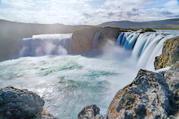 Godafoss waterfall, foggy from waterspray on a cloudy morning, Iceland