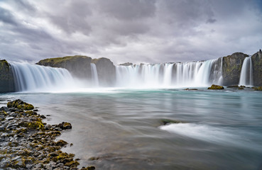 Godafoss waterfall, foggy from waterspray on a cloudy morning, Iceland