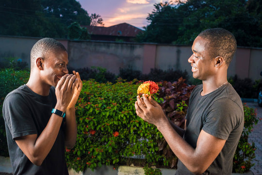 Young Black Man Surprises His Gay Partner With Flowers Outdoor, Both Laughing