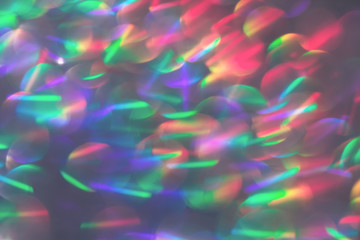 Multicolor blurred neon lights star flares and rainbow glitter on dark background. Bokeh lens flare...