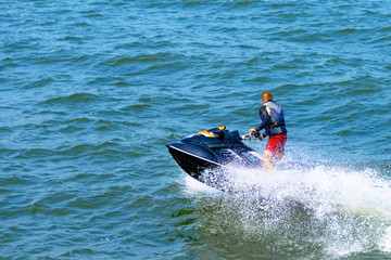 Man on a water bike on the nice blue sea. One man riding water bikes during the holidays.