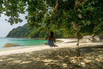 Fototapeta premium Turtle Beach, Besar, Perhentian Islands, Malaysia; 19-May-2019; A lady on a swing, Turtle Beach, Besar, Perhentian Islands, Malaysia