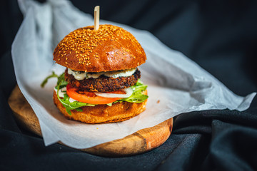 Freshly made forest burger with rucola, onions, grilled portobello and garlic souce on dark...
