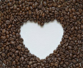 background of roasted coffee beans with a heart on a white background