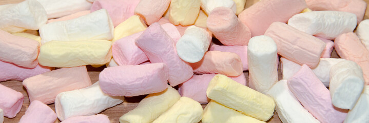 Multicolored marshmallows close-up as a background. White, yellow, pink
